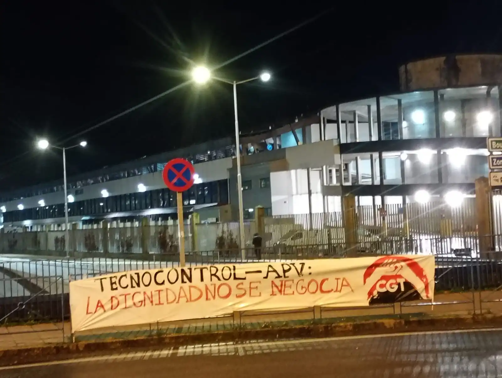 Pancarta en las calles cerca del puerto con el texto "Tecnocontrol - APV: La dignidad no se negocia"